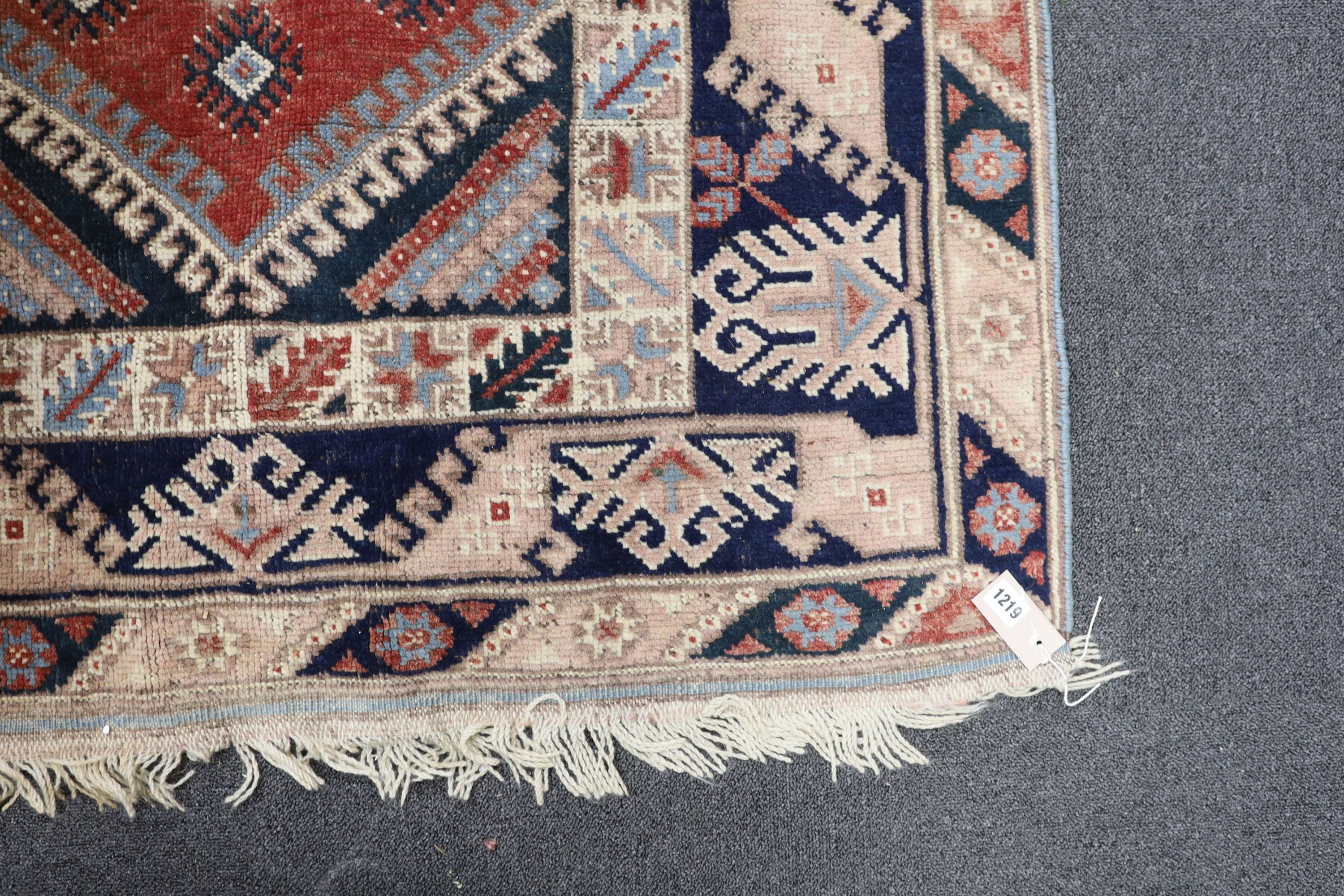 A Caucasian red ground rug and a Bokhara runner, rug 180 x 120 cms